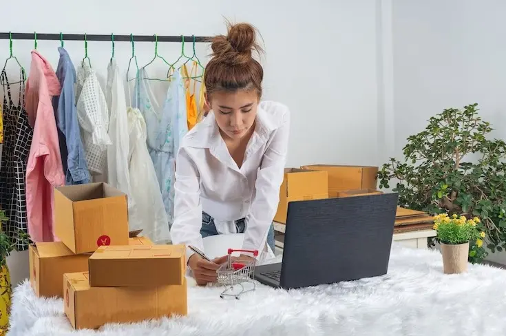 A business woman is working online and traing to reply customer at home office packaging on wall.